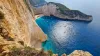 Zakynthos Beach: Navagio, Greece - crystal clear ocean waters, pristine sandy shores, and dramatic natural cliffs.